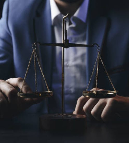 justice and law concept.Male lawyer in the office with brass scale on wooden table,reflected view